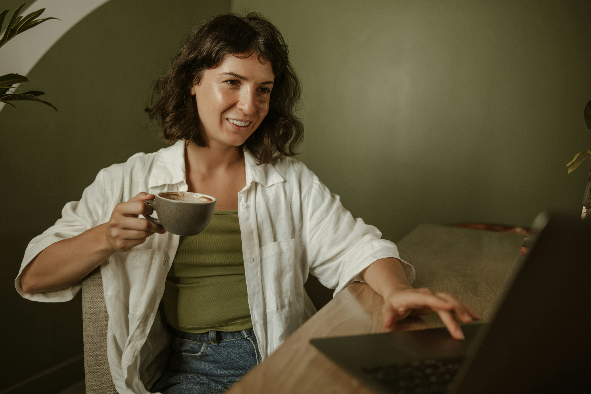 A client in a relaxed morning telehealth session at home with a cup of coffee